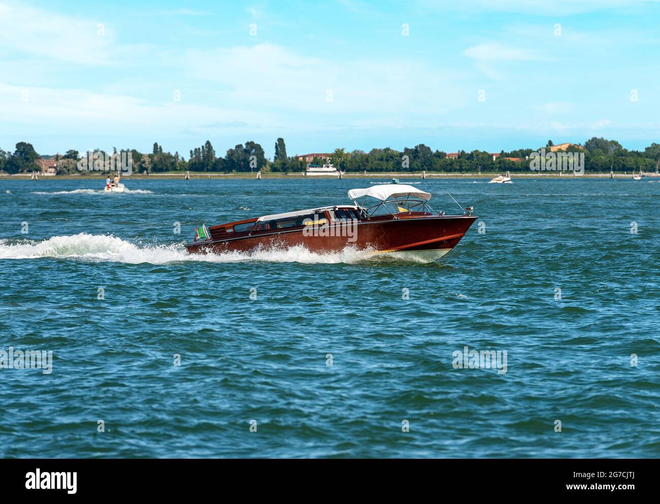 Tradizionale taxi acqueo in movimento fatto di legno nella laguna di Venezia, il modo più veloce per viaggiare in questa città. Italia, Veneto, Europa. Foto Stock