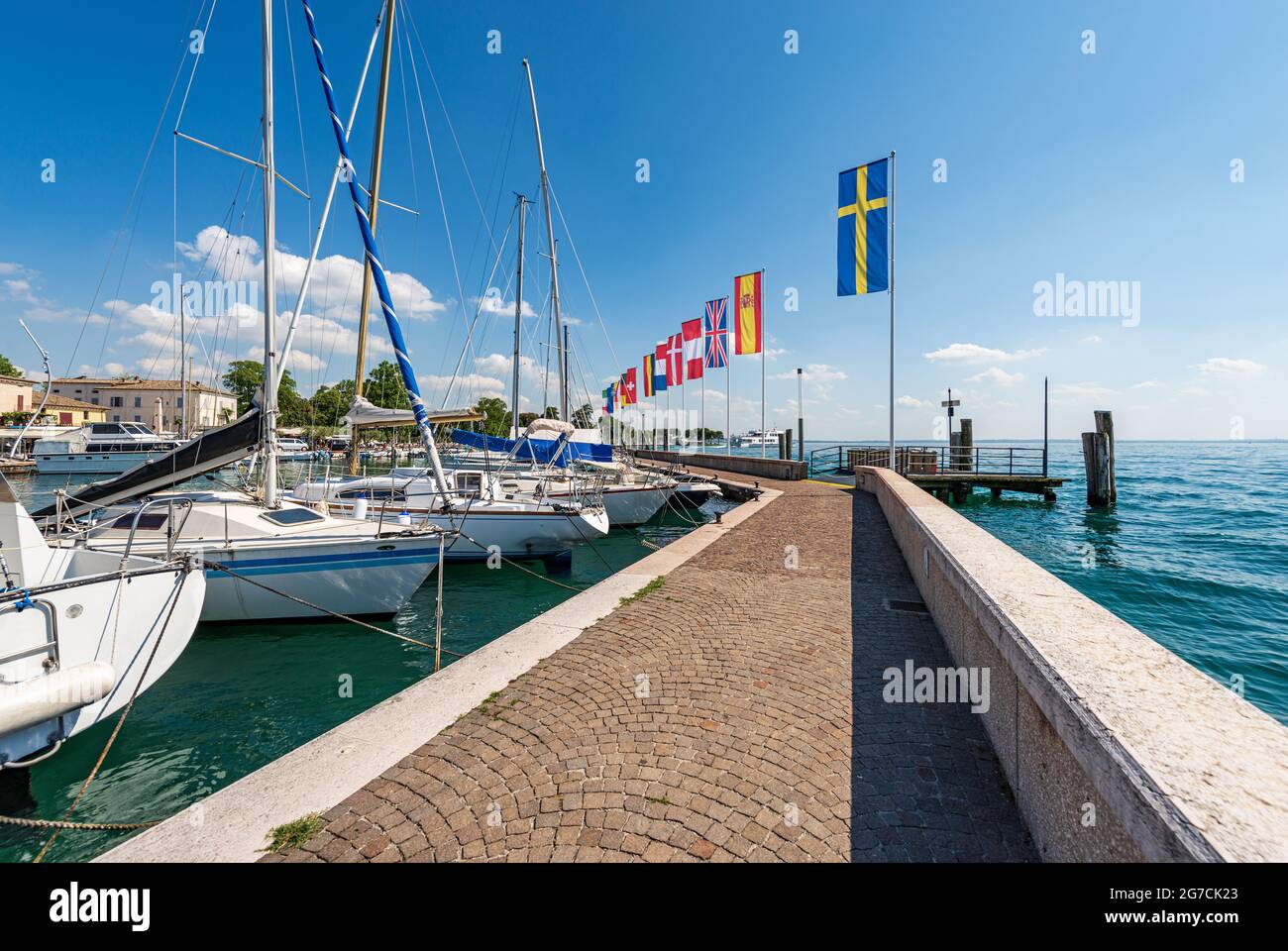 Porto del piccolo borgo di Bardolino con barche a vela ormeggiate, località turistica sulla costa del Lago di Garda. Verona, Veneto, Italia. Foto Stock