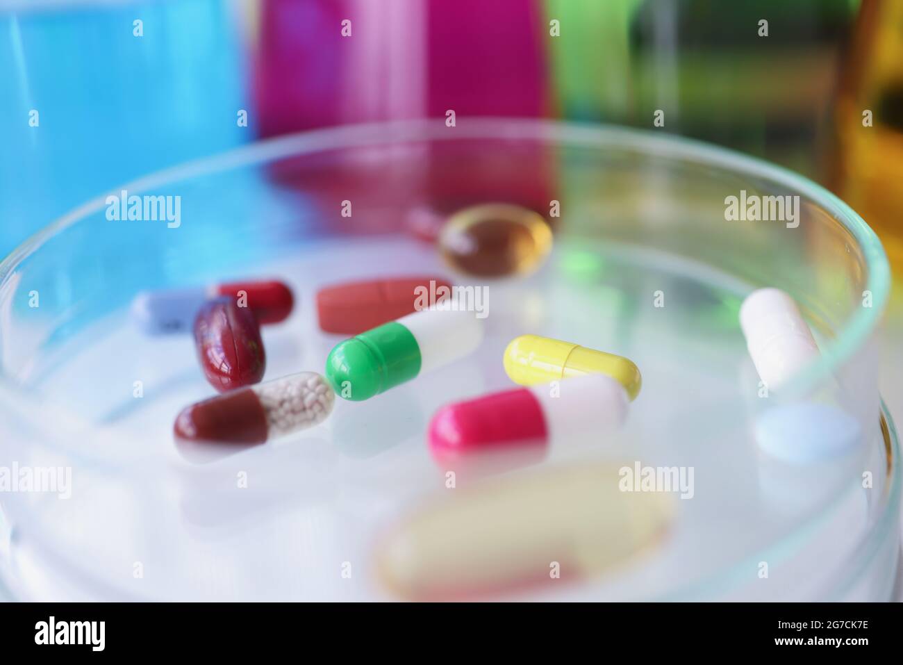 Pillole mediche multicolore si trovano sulla provetta di vetro closeup Foto Stock