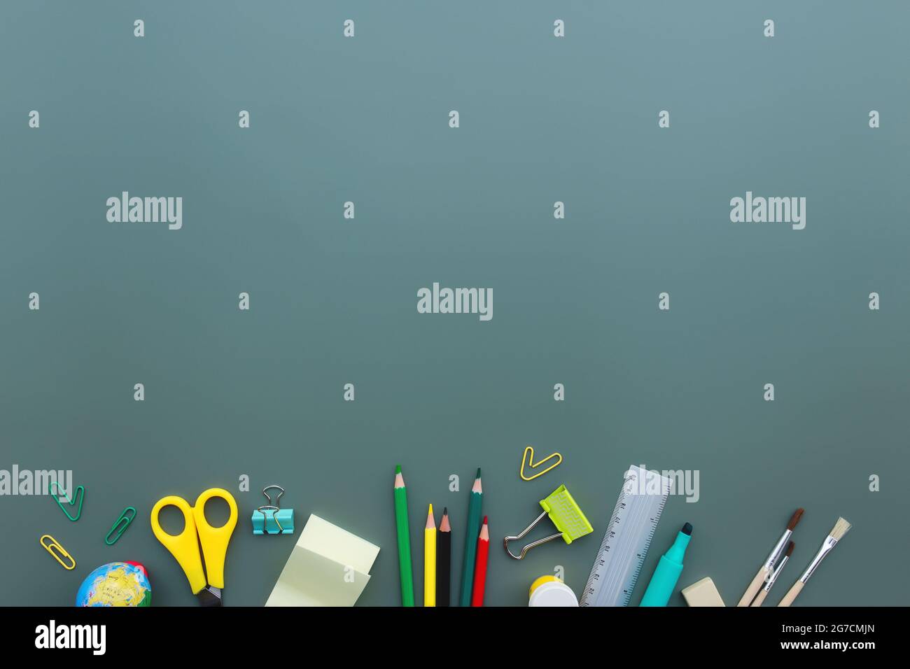 Piano concettuale di ritorno a scuola con diversi oggetti di forniture per ufficio su sfondo verde. Concetto per alunni della scuola primaria e secondaria. Forbici, Foto Stock