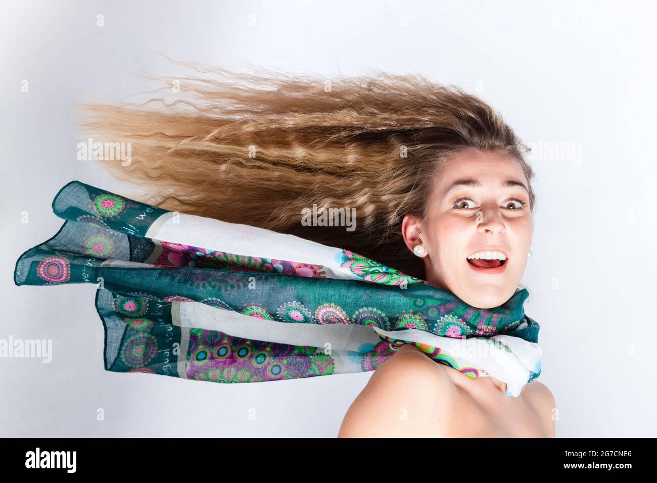 Capelli lunghi di donna con sciarpa soffiando nel vento di testa Foto Stock