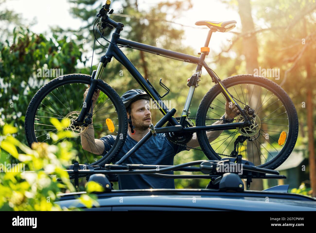 l'uomo prende la mountain bike dal portapacchi dell'auto Foto Stock