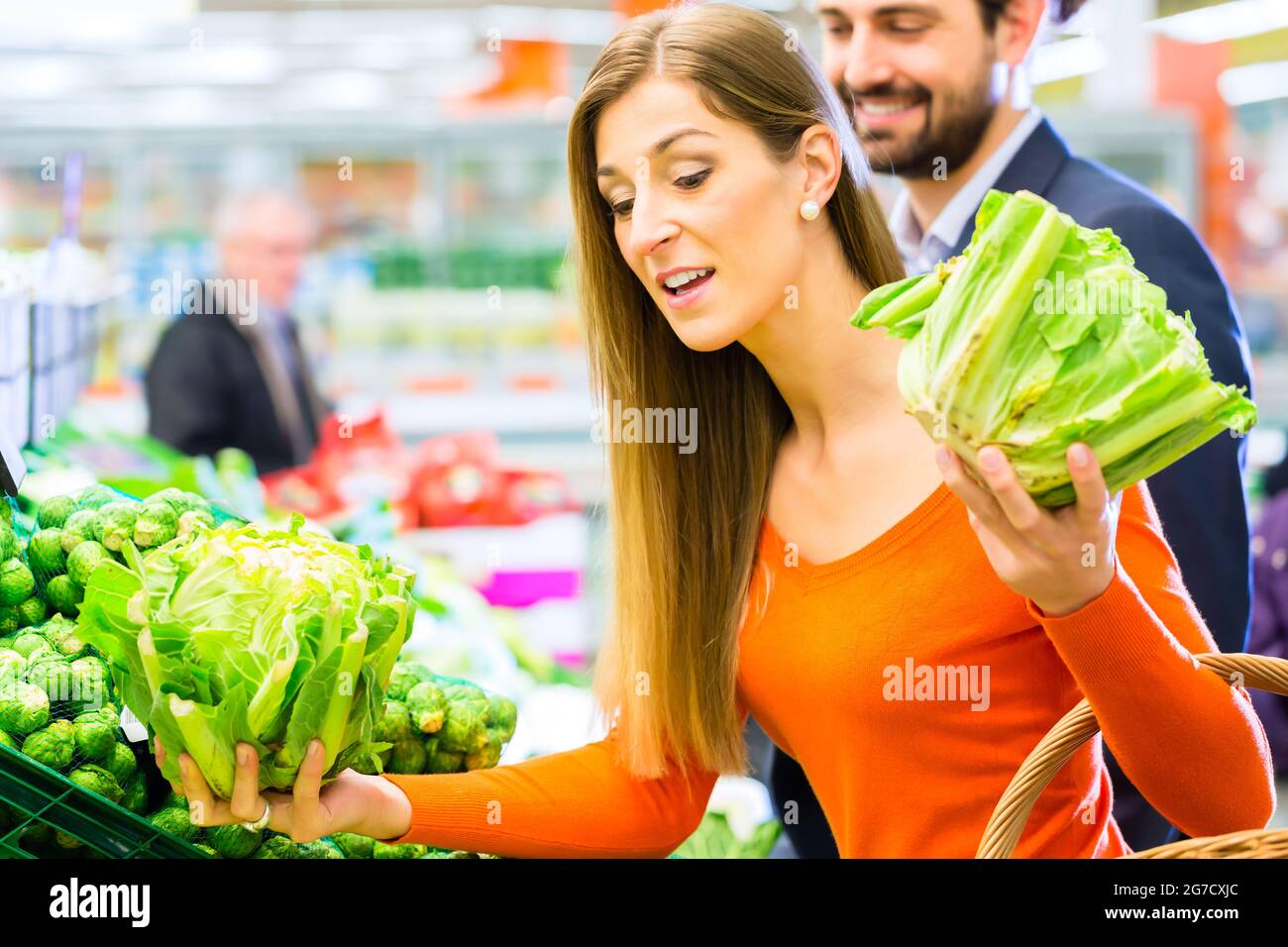 Matura nel supermercato al ripiano di vegetali shopping per negozi di generi alimentari Foto Stock
