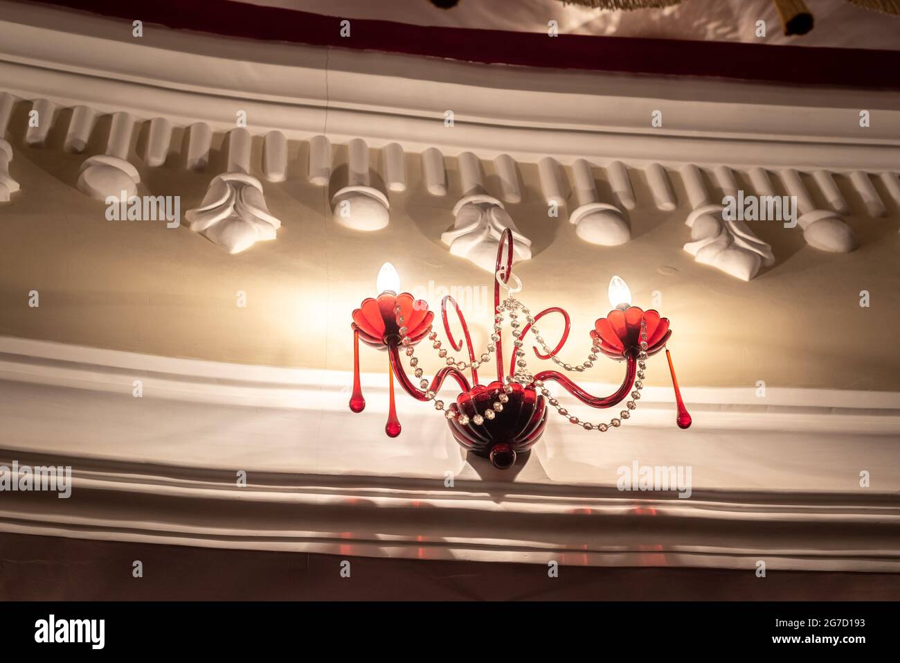 Elegante lampadario di vetro rosso con perline su pareti decorate Foto Stock