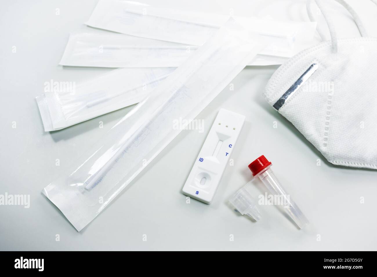 Kit di test automatico per antigene rapido per la diagnostica a domicilio Covid-19 con tamponi nasali, provette, dispositivo di rilevamento e maschera facciale ffp-2, fondo grigio chiaro, CO Foto Stock