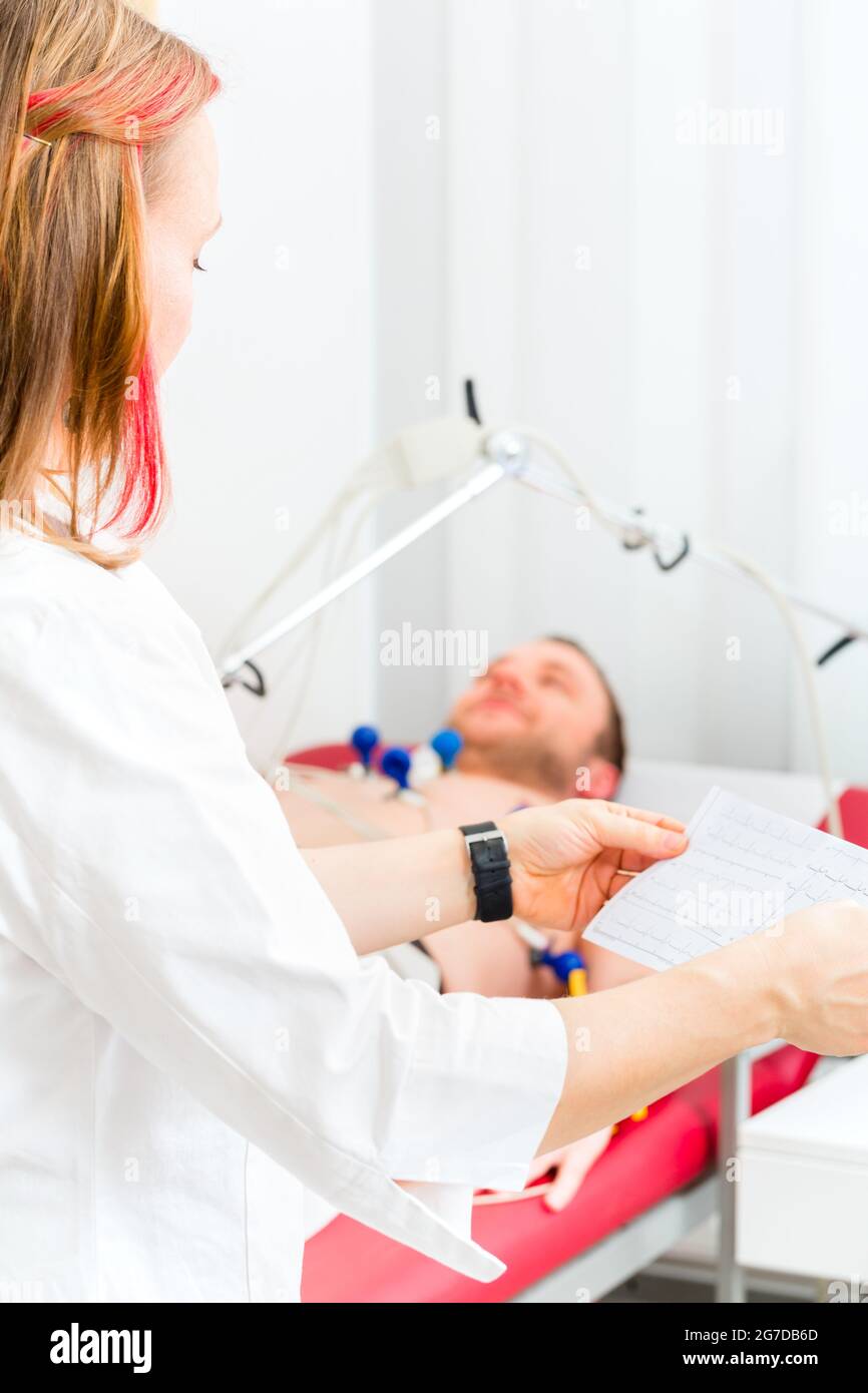 Medico donna analizzando elettrocardiogramma ECG del paziente in ospedale Foto Stock