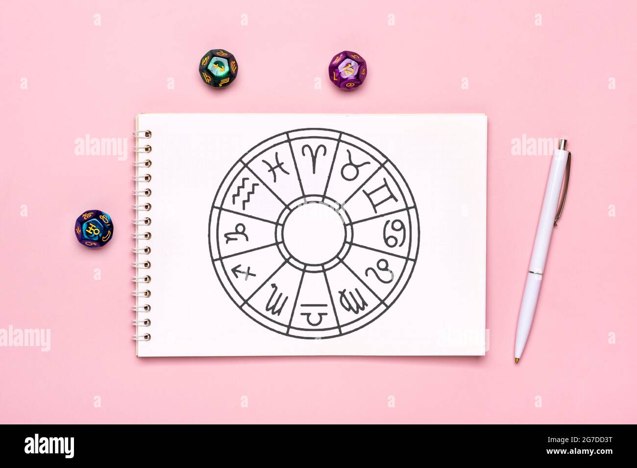 Cerchio oroscopo con dodici segni di zodiaco su carta, dadi divination, pietra colorata su sfondo rosa Fortune raccontare e astrologia predizioni Foto Stock