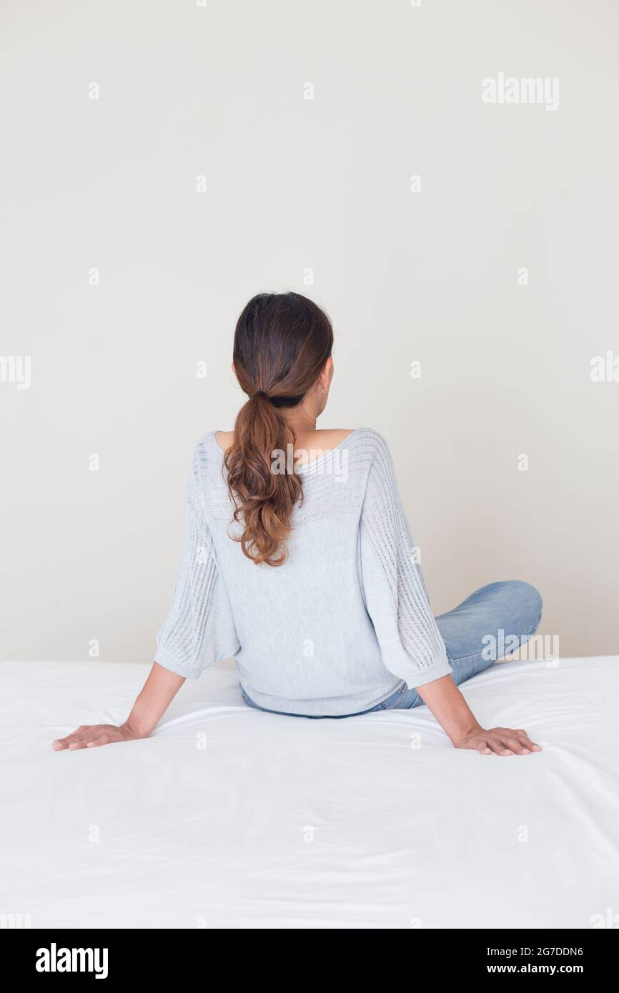 Vista posteriore di una donna che guarda a un muro Foto Stock