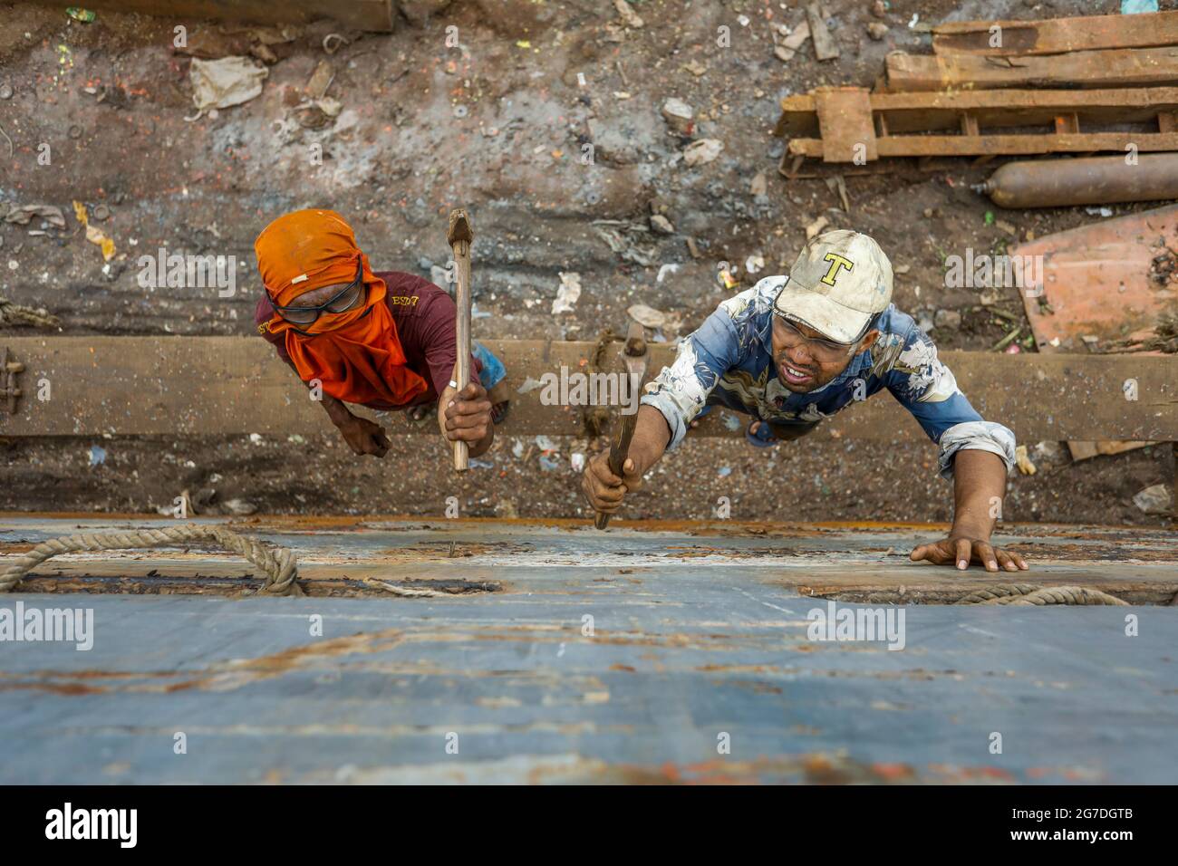 I lavoratori del Bangladesh riparano una nave in un cantiere navale sulla riva del fiume Buriganga, a Keraniganj, vicino a Dhaka, Bangladesh, luglio 13; 2021. Con un incremento Foto Stock