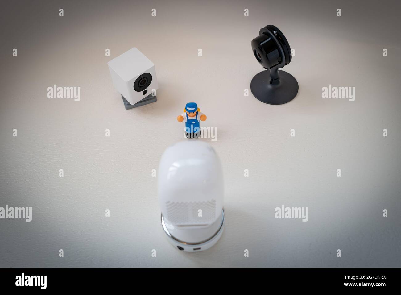 Immagine illustrativa di un giocattolo di plastica per bambini circondato da telecamere di sicurezza di Google Nest, Simcam e Wyze su sfondo bianco, che suggerisce la sorveglianza di massa, a San Ramon, California, novembre 20, 2020. () Foto Stock