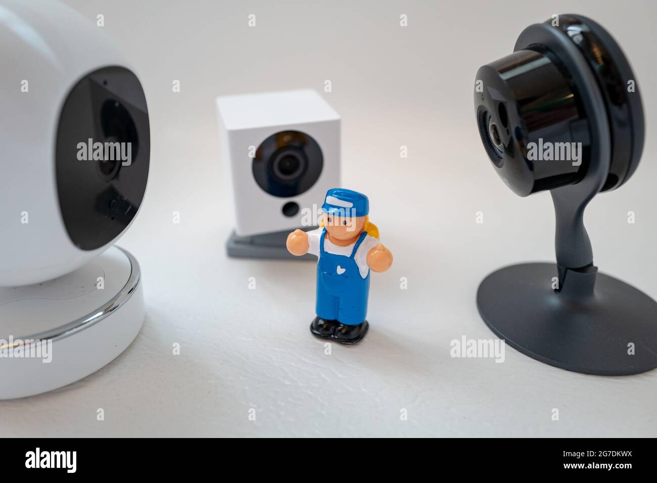 Immagine illustrativa di un giocattolo di plastica per bambini circondato da telecamere di sicurezza di Google Nest, Simcam e Wyze su sfondo bianco, che suggerisce la sorveglianza di massa, a San Ramon, California, novembre 20, 2020. () Foto Stock