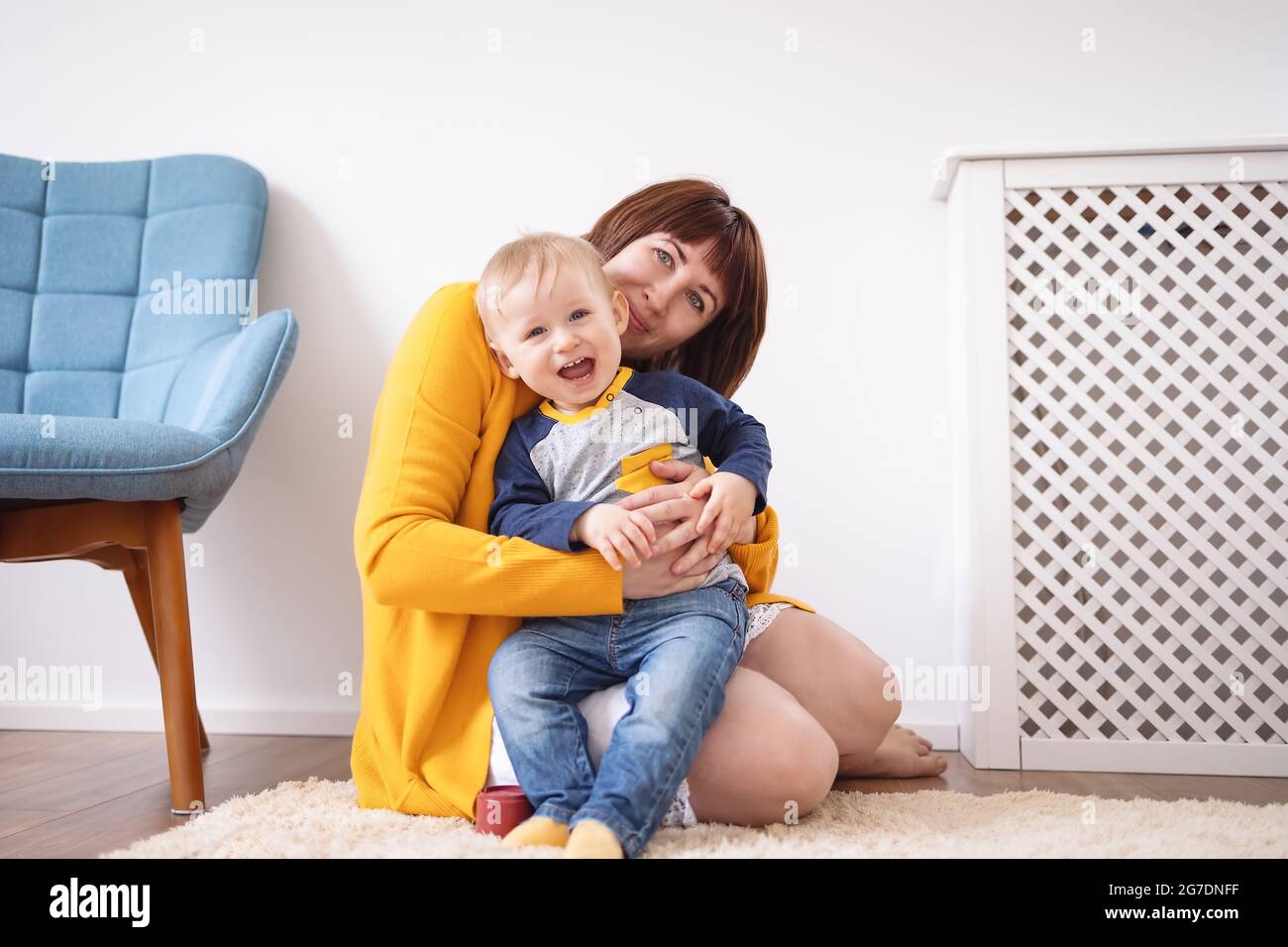 Giovane madre abbracciando con cura il suo figlio carino Foto Stock