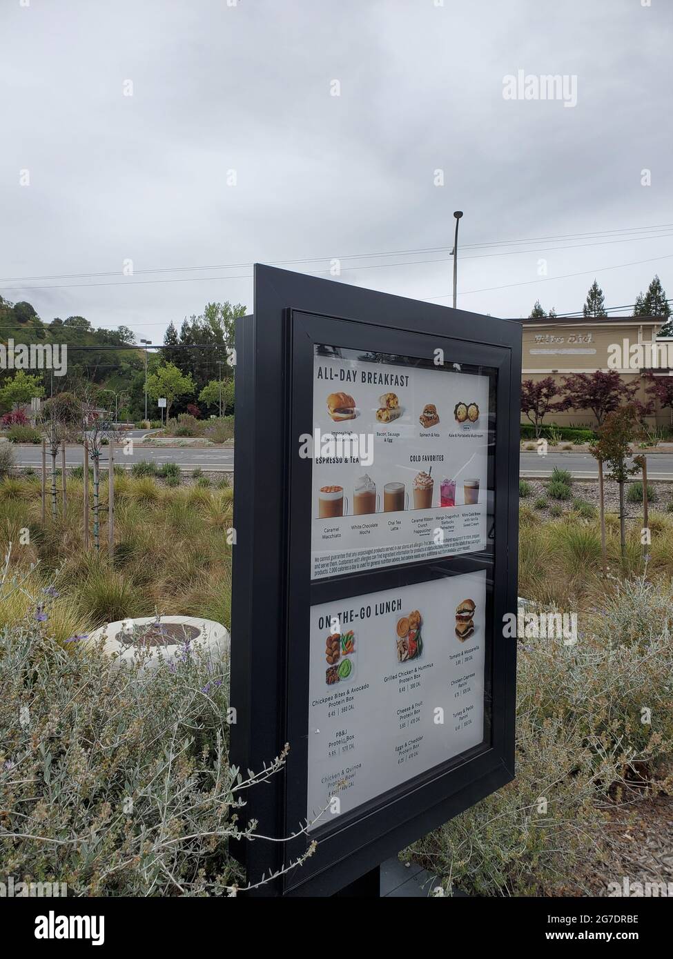 Fotografia angolata di un menu da asporto di Starbucks montato ai margini di un campo suburbano a Rossmoor, Walnut Creek, California, 25 aprile 2021. () Foto Stock