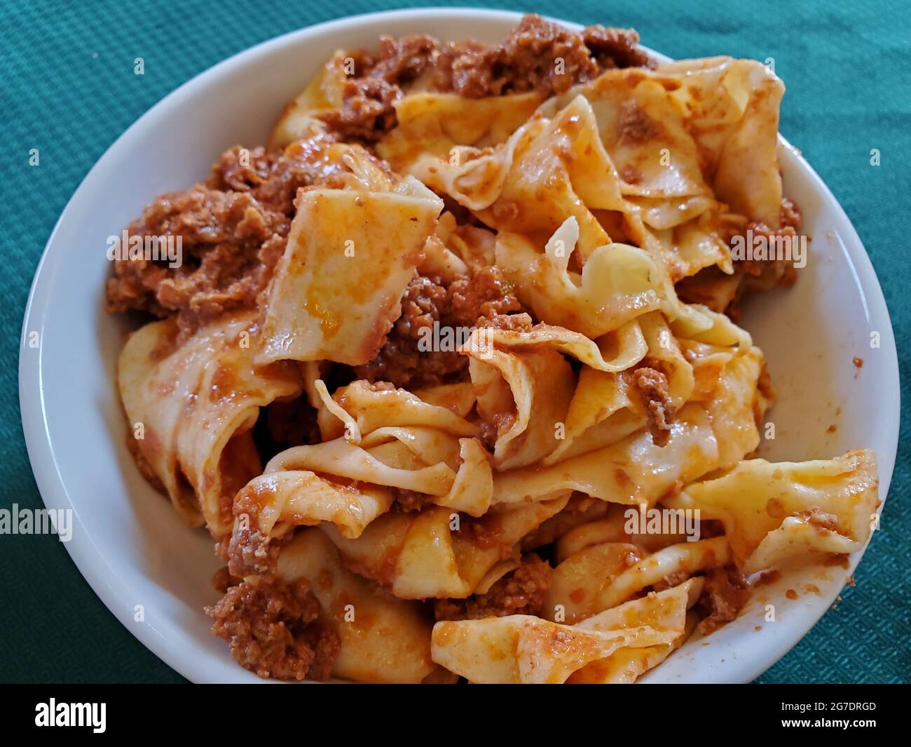 Primo piano di pappardelle appena cotte con salsa di carne in una ciotola bianca poggiata su una tovaglia verde, fotografata a Lafayette, California, 30 aprile 2021. () Foto Stock