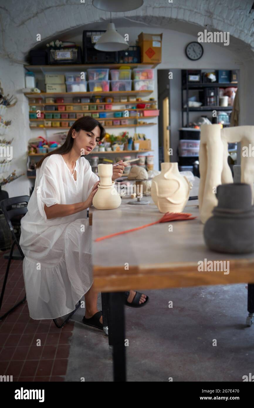 Una donna che fa ceramica durante la sua classe di ceramica Foto Stock