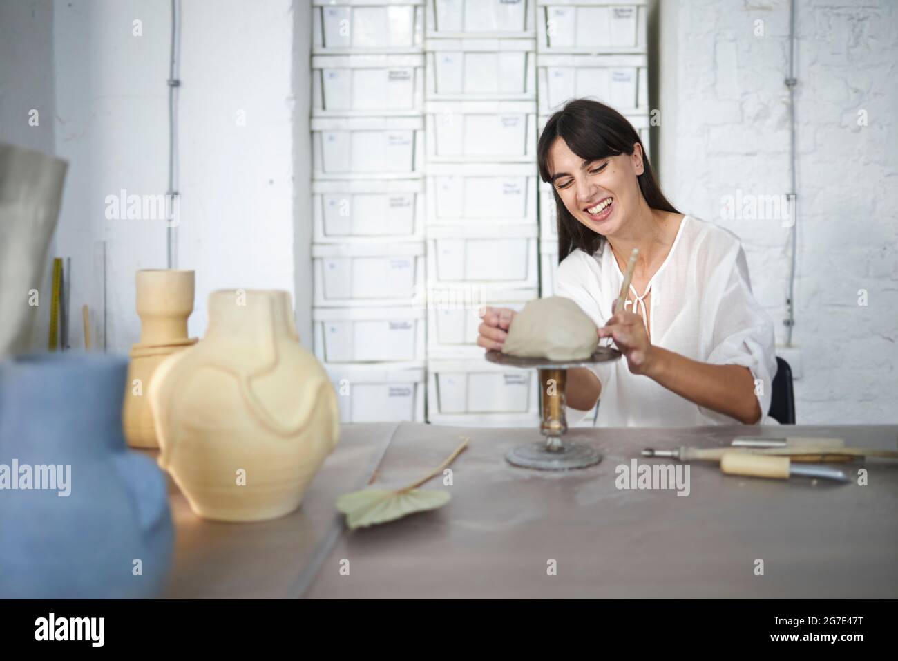 Donna ridendo e godendo la sua classe di ceramica Foto Stock