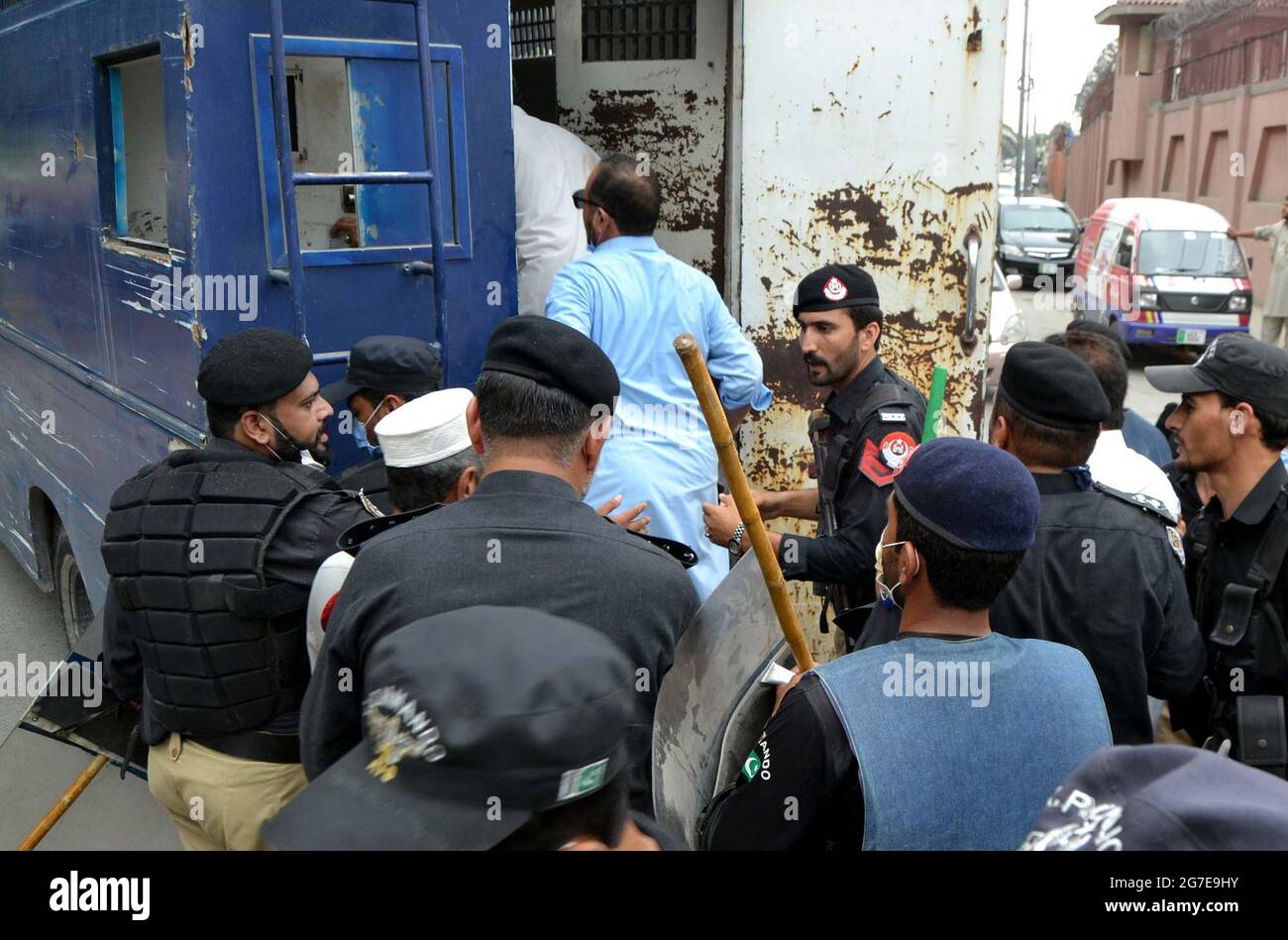 Funzionari di polizia che arrestano i dipendenti del governo mentre tentavano di spostarsi verso la zona rossa durante la loro manifestazione di protesta per l'aumento di stipendio, fuori dall'Assemblea di Khyber Pakhtunkhwa a Peshawar martedì 13 luglio 2021. Foto Stock