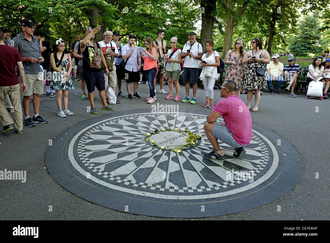 I turisti rendono omaggio a John Lennon al memoriale Strawberry Fields, in Central Park, a New York City. Foto Stock
