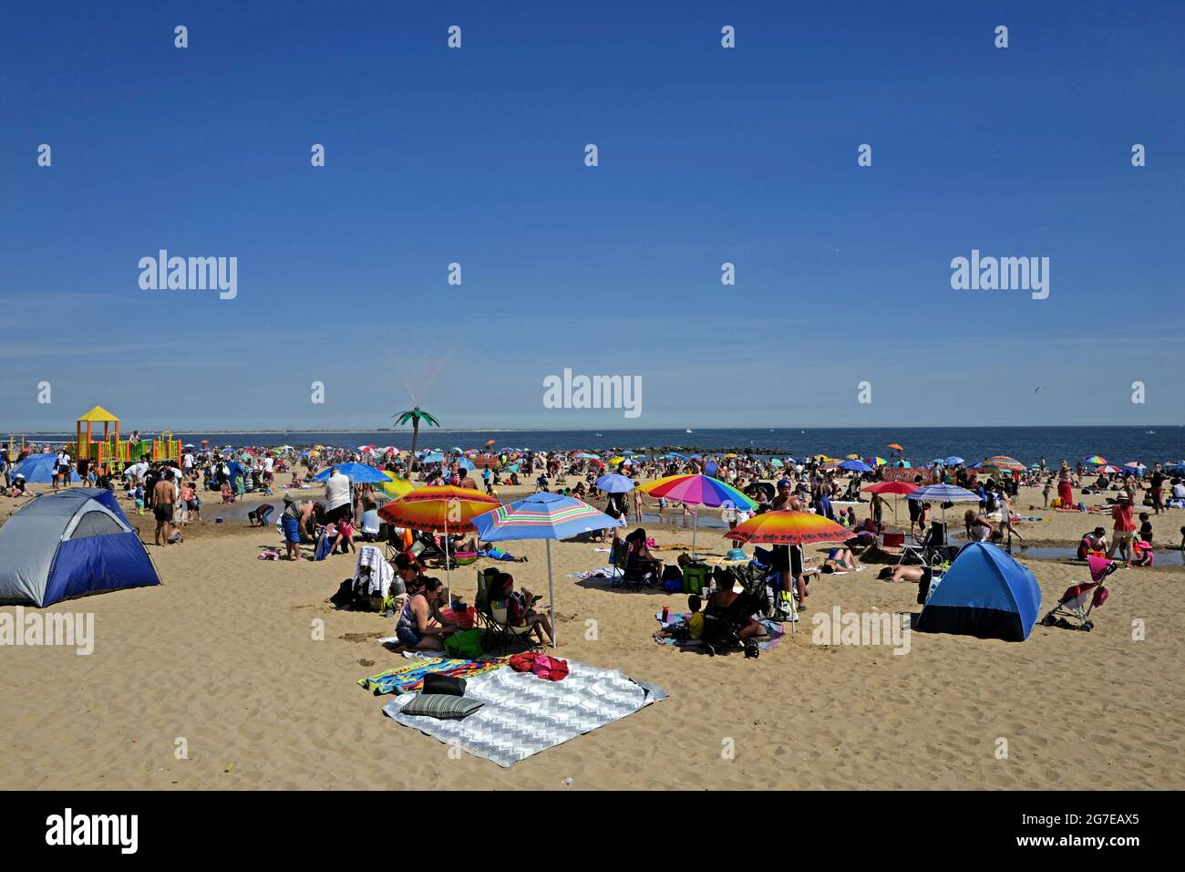 La gente alla spiaggia di Coney Island durante un caldo pomeriggio di domenica di Estate, a New York City. Foto Stock