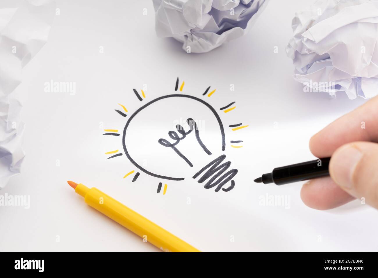 Concetto di idea brillante. Luce di disegno a mano sulla carta e carta sgualcita. Concetto di processo creativo Foto Stock