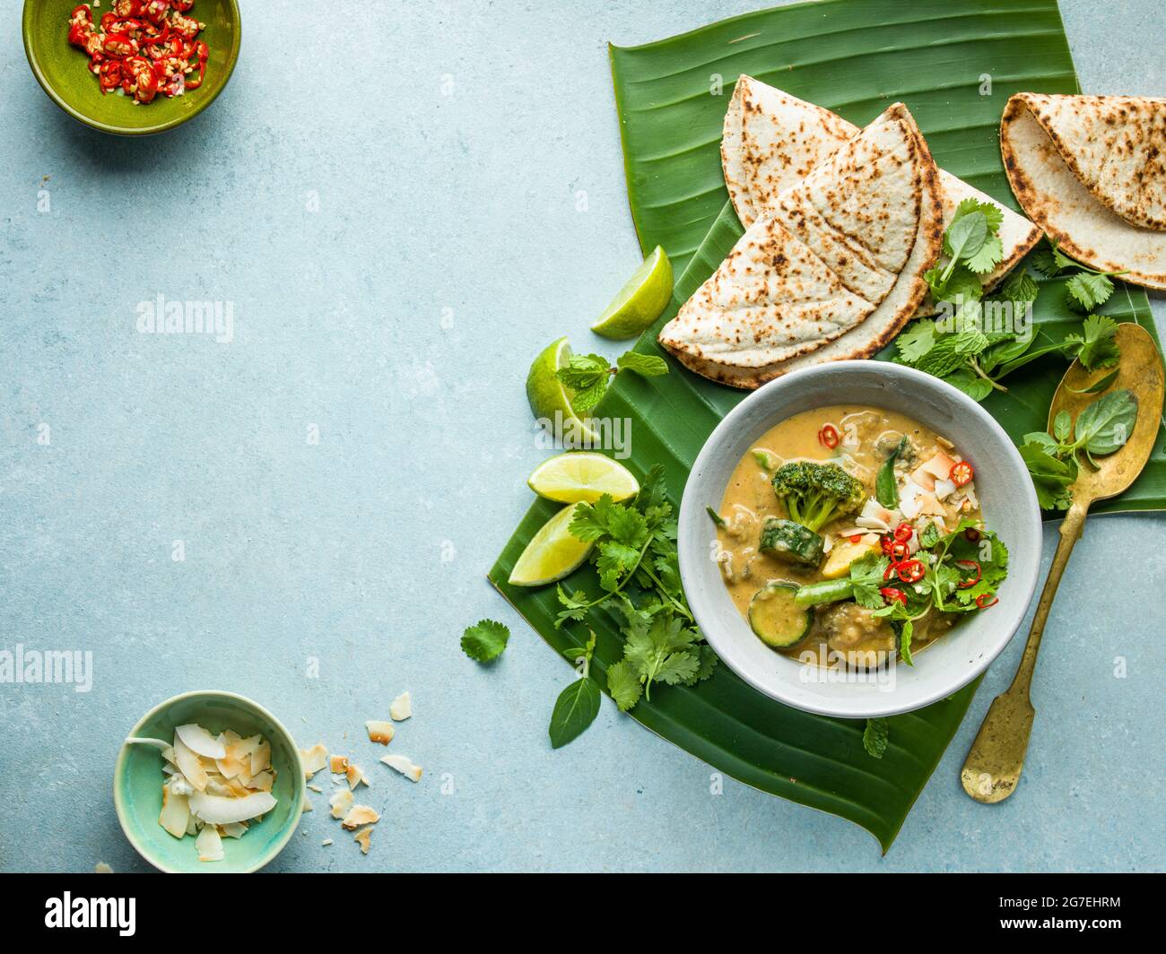 Curry vegetale e roti di cocco su foglie di palma Foto Stock