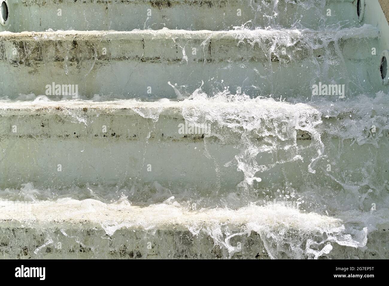 Spruzzi d'acqua della fontana che scorre su una serie di gradini di cemento Foto Stock