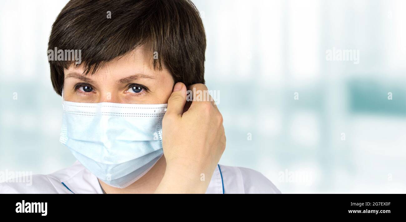 Concetto di blocco finale. Femmina Dottore toglie la sua maschera. Concetto di lotta contro l'infezione da coronavirus covid 19. Pandemia, Covid-19, epidemia, coronavirus Foto Stock