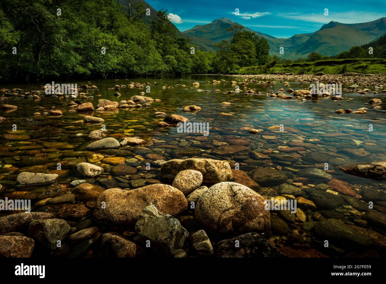 Un primo piano di una roccia accanto a un corpo d'acqua a Glen Nevis Scozia Foto Stock