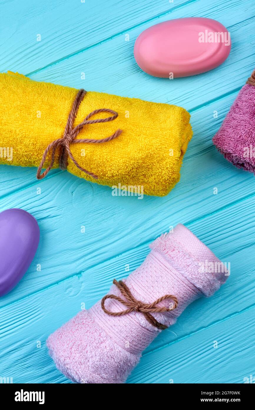 Tovaglioli e saponette in spugna colorata su legno blu. Foto Stock