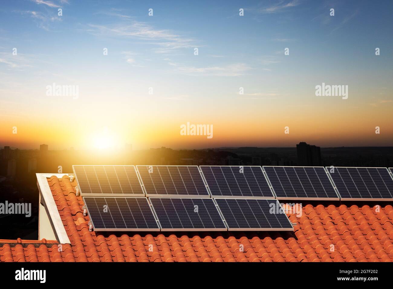 Pannelli fotovoltaici solari su un tetto al tramonto. Energia pulita immagine di concetto casa o azienda moderna. Foto Stock