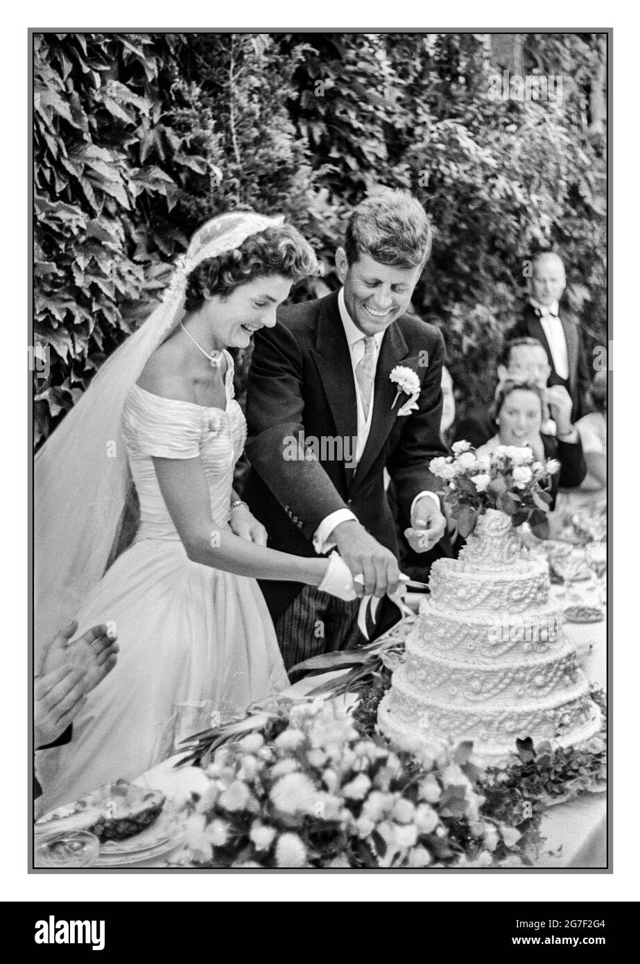 JACK KENNEDY JFK WEDDING DAY CAKE CUTTING [Jackie Bouvier Kennedy e John (Jack) F. Kennedy tagliando la torta al loro matrimonio, 12 settembre 1953, Newport, Rhode Island Foto Stock