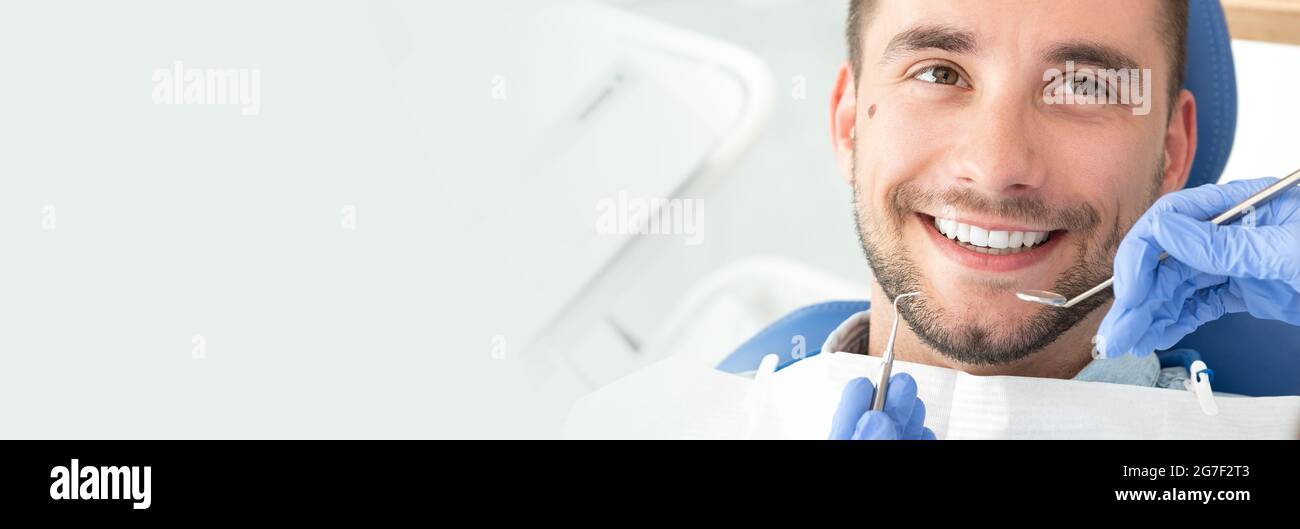 Giovane uomo dal dentista. Per le cure dentarie, avendo cura di denti. Immagine con copia spazio per lo sfondo. Foto Stock