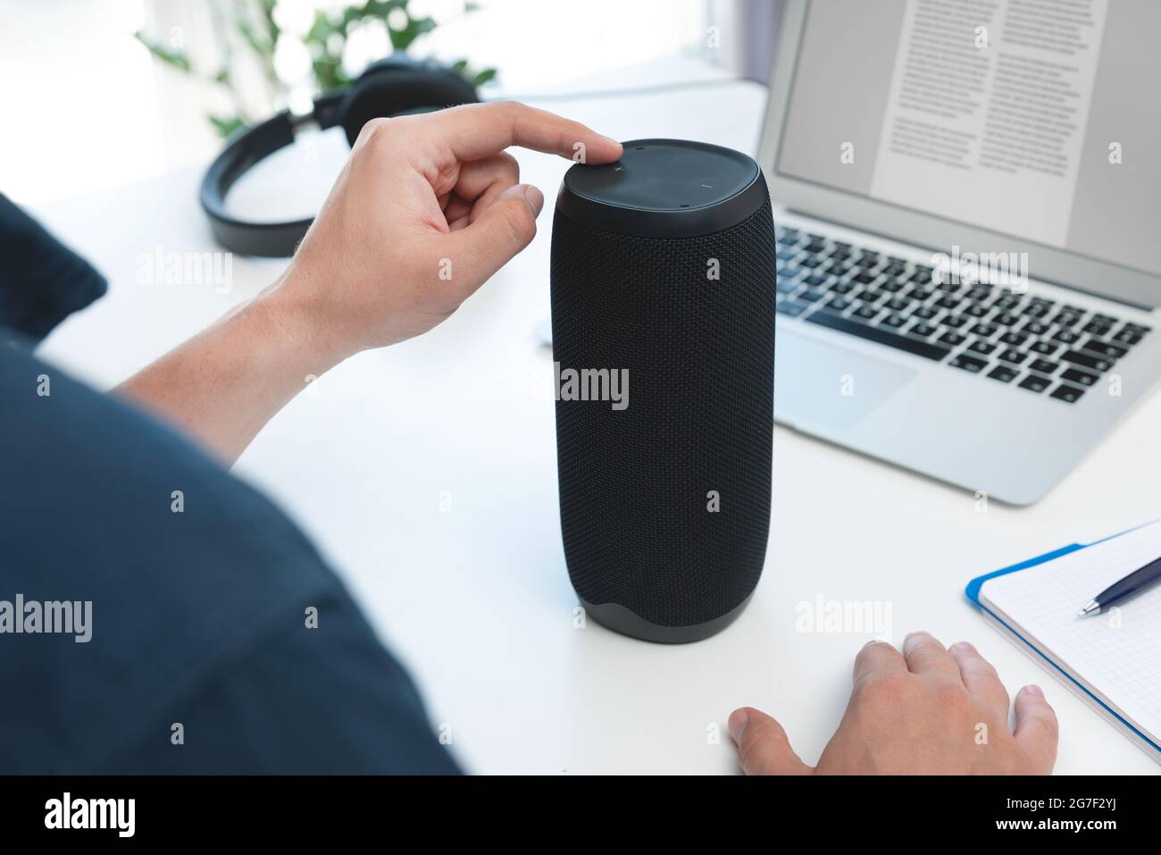 Uomo che utilizza un altoparlante intelligente. Dispositivo domestico intelligente e moderno, assistente intelligente Foto Stock