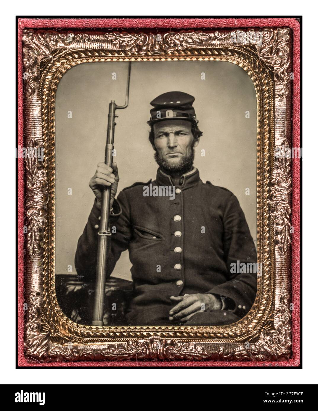 Ritratto ufficiale della Guerra civile americana 1860 per la famiglia prima di andare alla guerra Soldier in uniforme dell'Unione con musket bayoneted [tra il 1861 e il 1865] processo di tintinnio, tecnica di fotografia colorata a mano Foto Stock