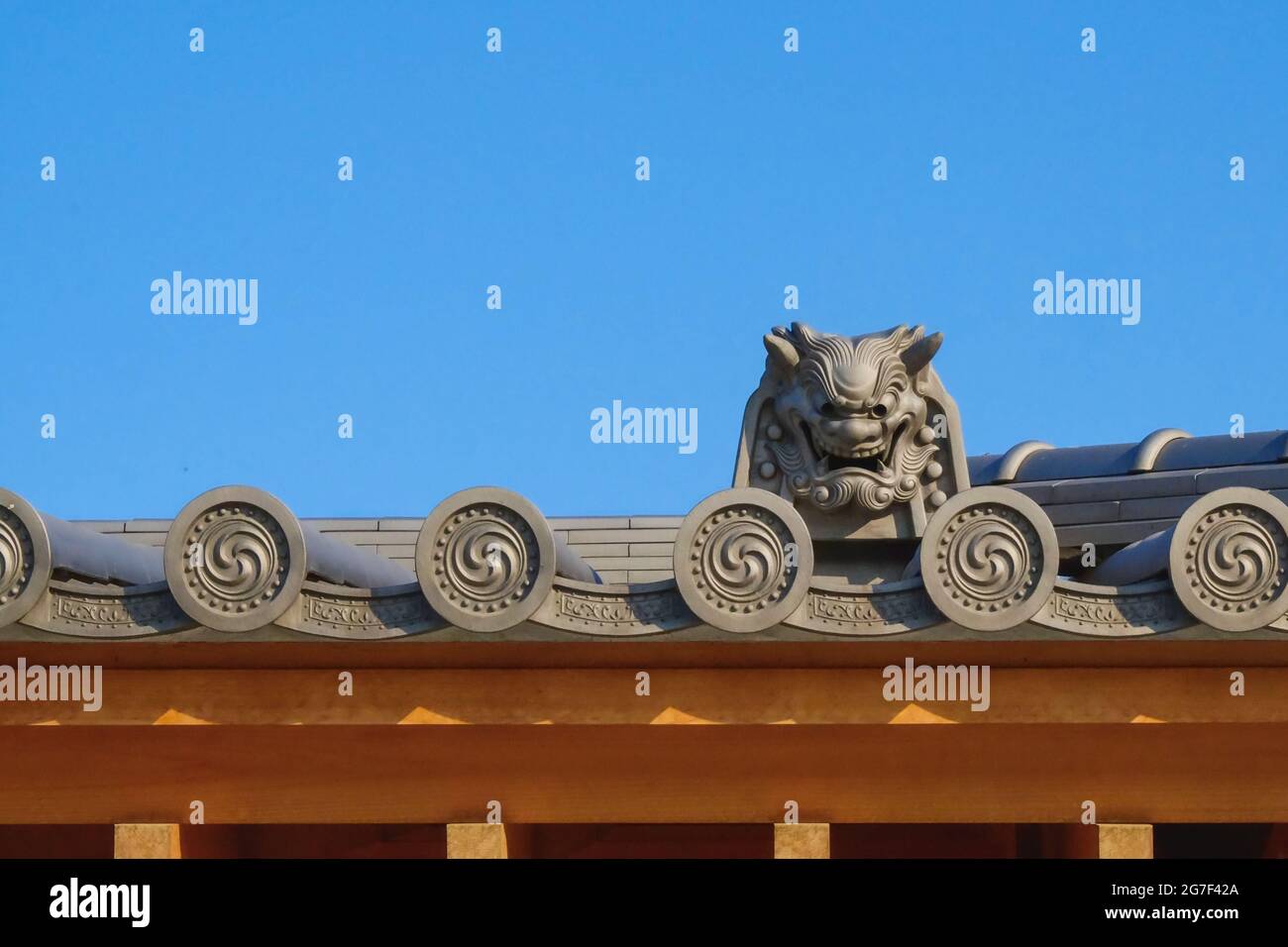 Frammento di classico giapponese, coreano tetto contro cielo blu con elementi decorativi tradizionali e motivi ripetibili. Foto Stock