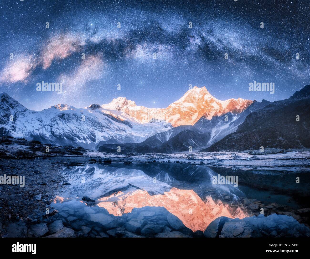 Milky Way su montagne innevate e lago di notte. Orizzontale Foto Stock