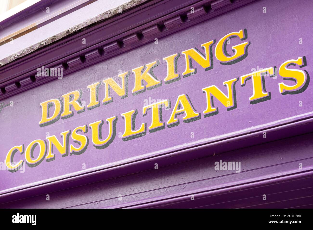 Drinking Consultants scrivendo sulla colorata facciata irlandese del bar a Tralee, County Kerry, Irlanda Foto Stock