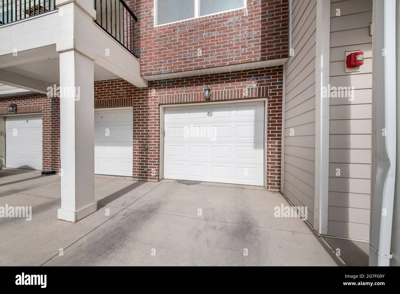 Tre porte per garage in sezione bianca di un edificio con mattoni Foto  stock - Alamy