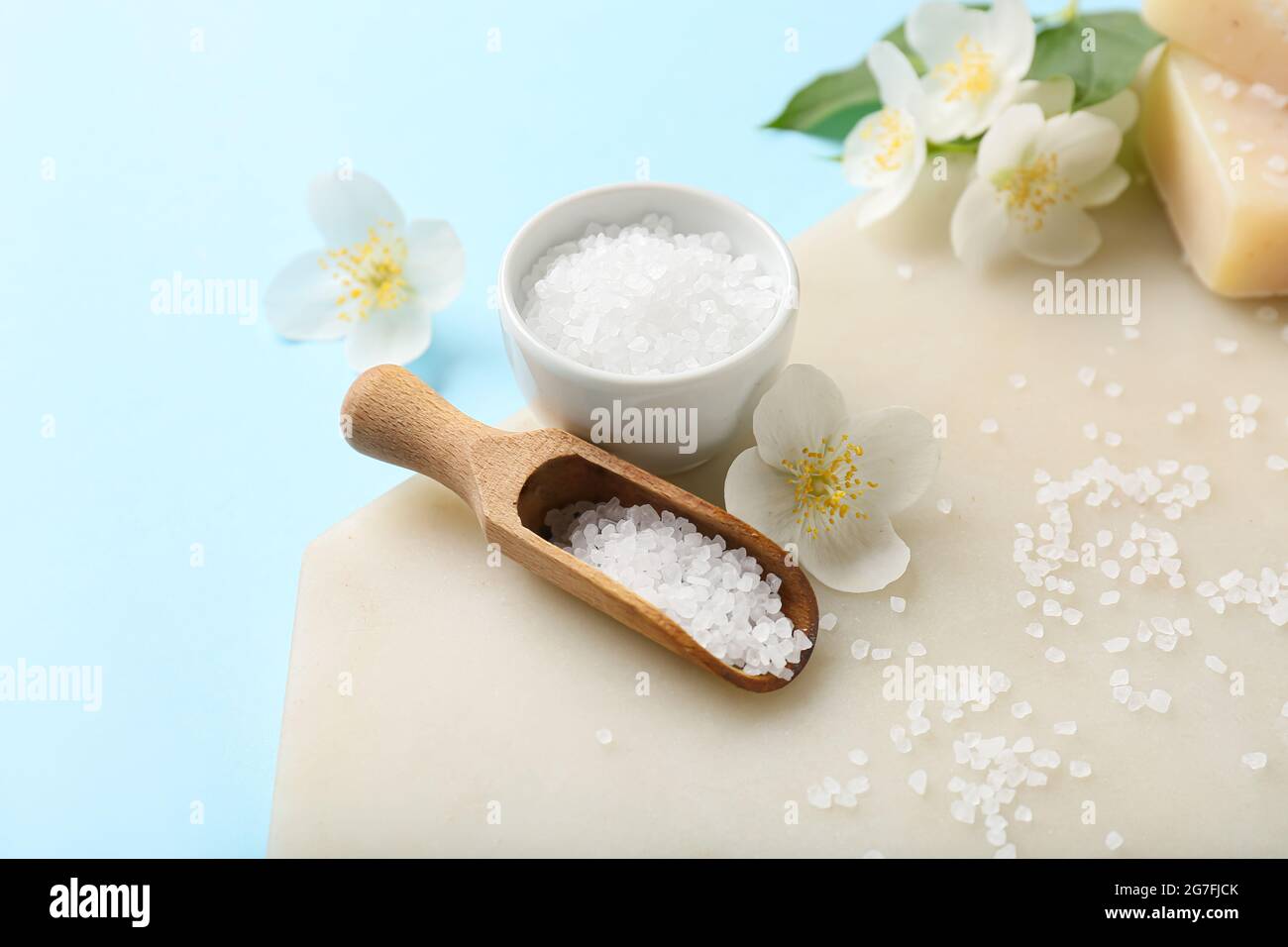 Composizione sale marino e fiori di gelsomino su sfondo colorato Foto Stock