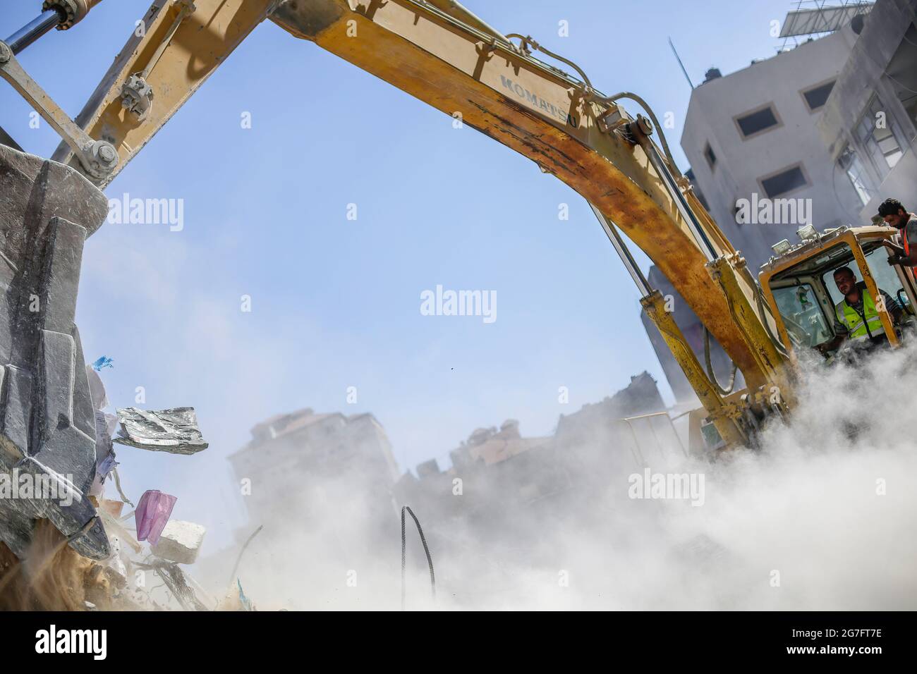 I lavoratori egiziani con macchine rimuovono le macerie delle torri e delle case distrutte dopo 11 giorni di combattimenti nel mese di maggio tra Israele e i militanti nella striscia di Gaza. Foto Stock