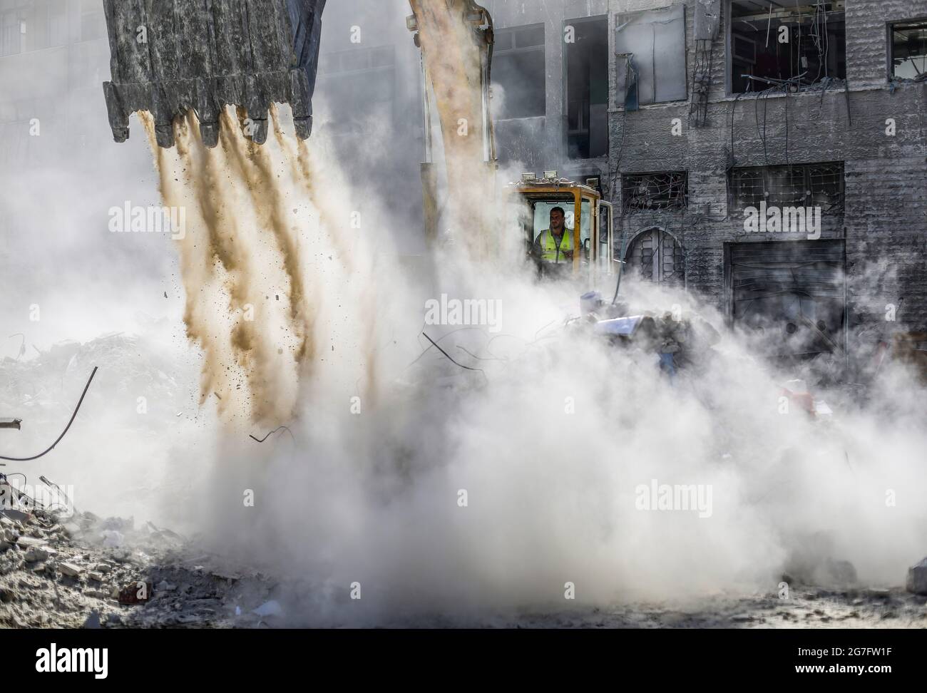 Gaza, Palestina. 4 luglio 2021. I lavoratori egiziani con macchine rimuovono le macerie delle torri e delle case distrutte dopo 11 giorni di combattimenti nel mese di maggio tra Israele e i militanti nella striscia di Gaza. Credit: Mahmoud Issa/SOPA Images/ZUMA Wire/Alamy Live News Foto Stock