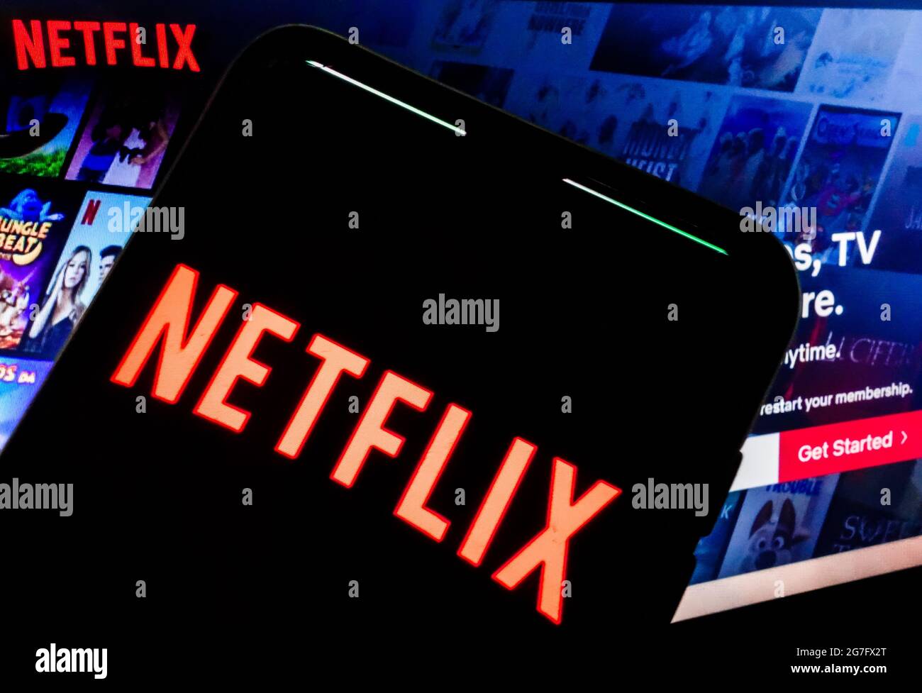 SAO PAULO, BRASILE - 03 luglio 2021: Logo Netflix visibile sullo schermo dello smartphone e homepage del sito web sullo sfondo Foto Stock