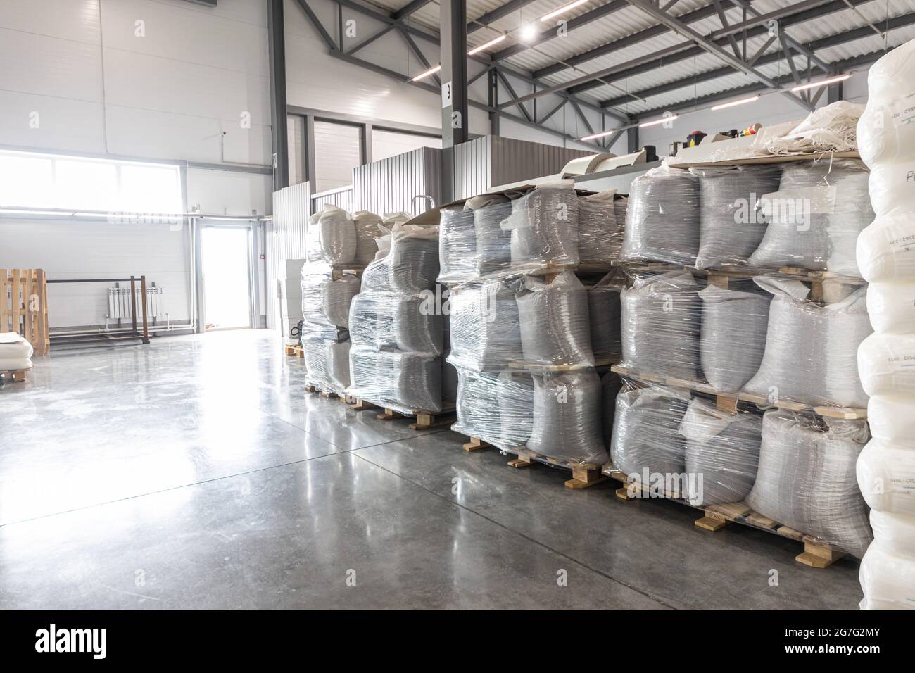 Magazzino spazioso in fabbrica con scaffali e ripiani speciali e prodotti collocati su di essi. Foto Stock