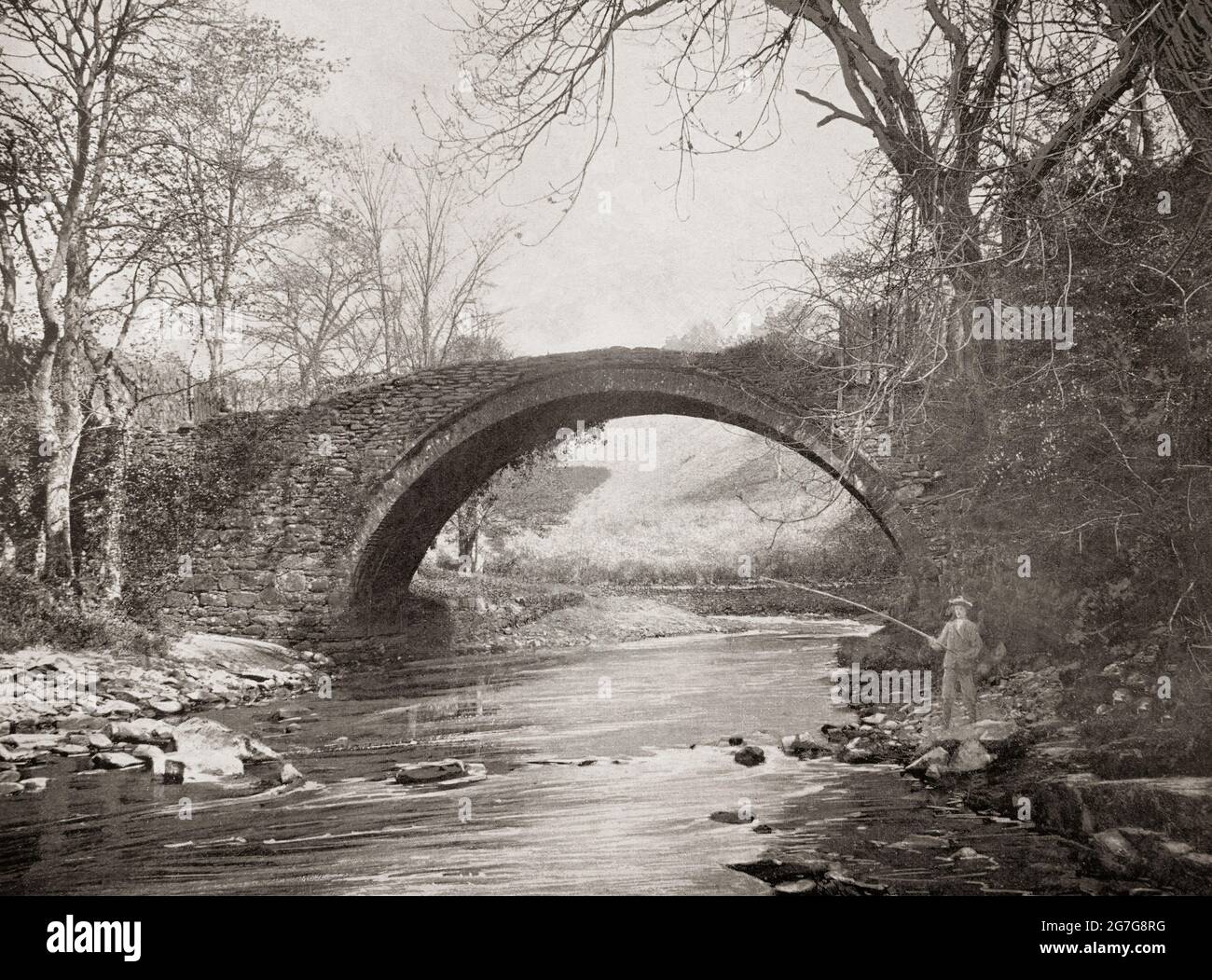 Una vista del tardo 19 ° secolo di un pescatore sotto il 'Ponte Romano' sul fiume Mousemill appena a ovest di Lanark, una città nella cintura centrale della Scozia. Probabilmente il Mousemill Bridge, menzionato per la prima volta nel 1587. Il ponte di pietra che si erge oggi sembra essere stato costruito e sostituito con una struttura in legno intorno al 1649. All'inizio del 19 ° secolo il moderno ponte è stato costruito a pochi metri di distanza e il vecchio permesso di cadere in decadimento. Così probabilmente di dubbia eredità romana! Foto Stock