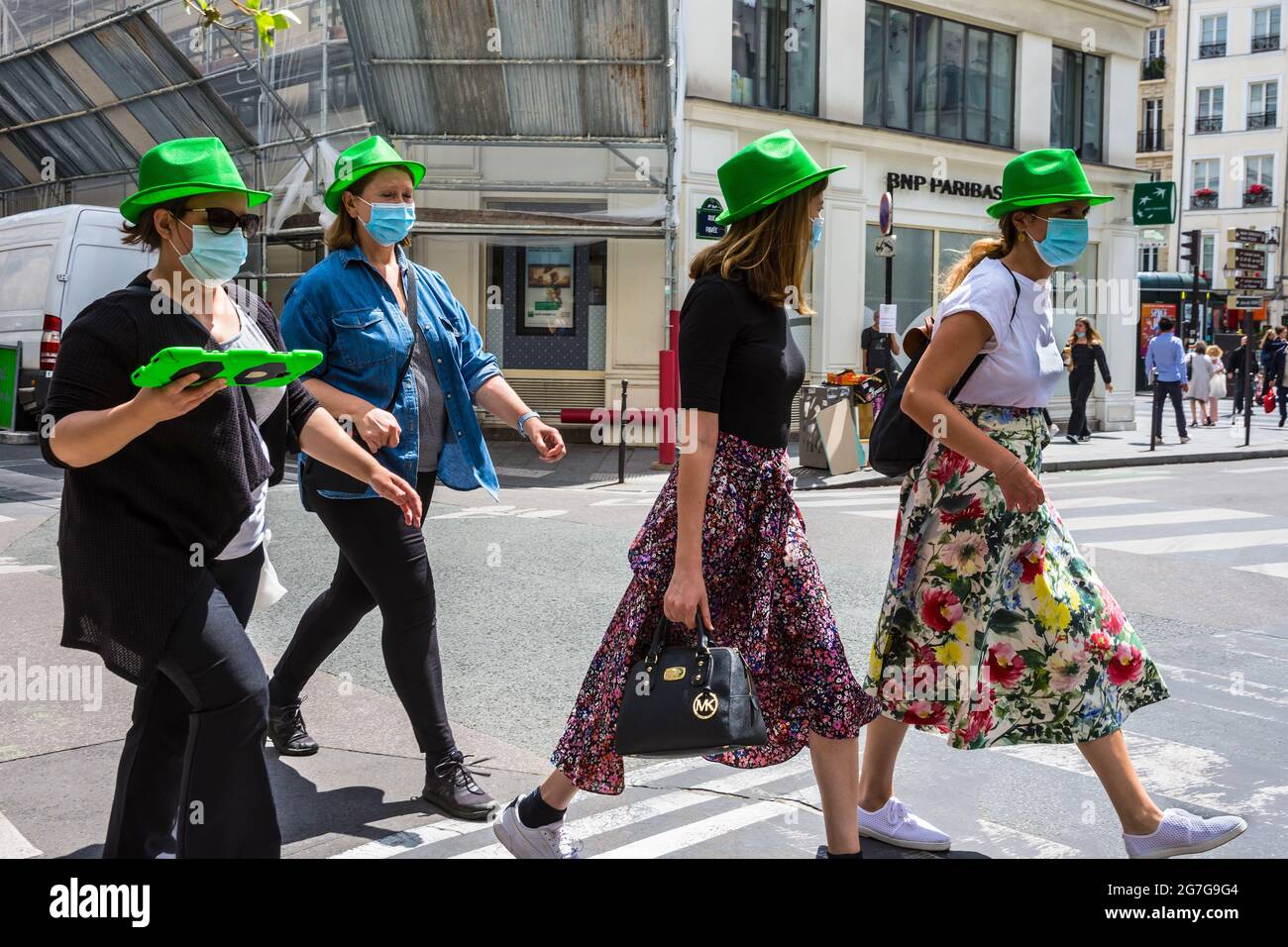 Gruppo di donne che indossano cappelli verdi in un tour guidato a piedi della città - Parigi, Francia. Foto Stock