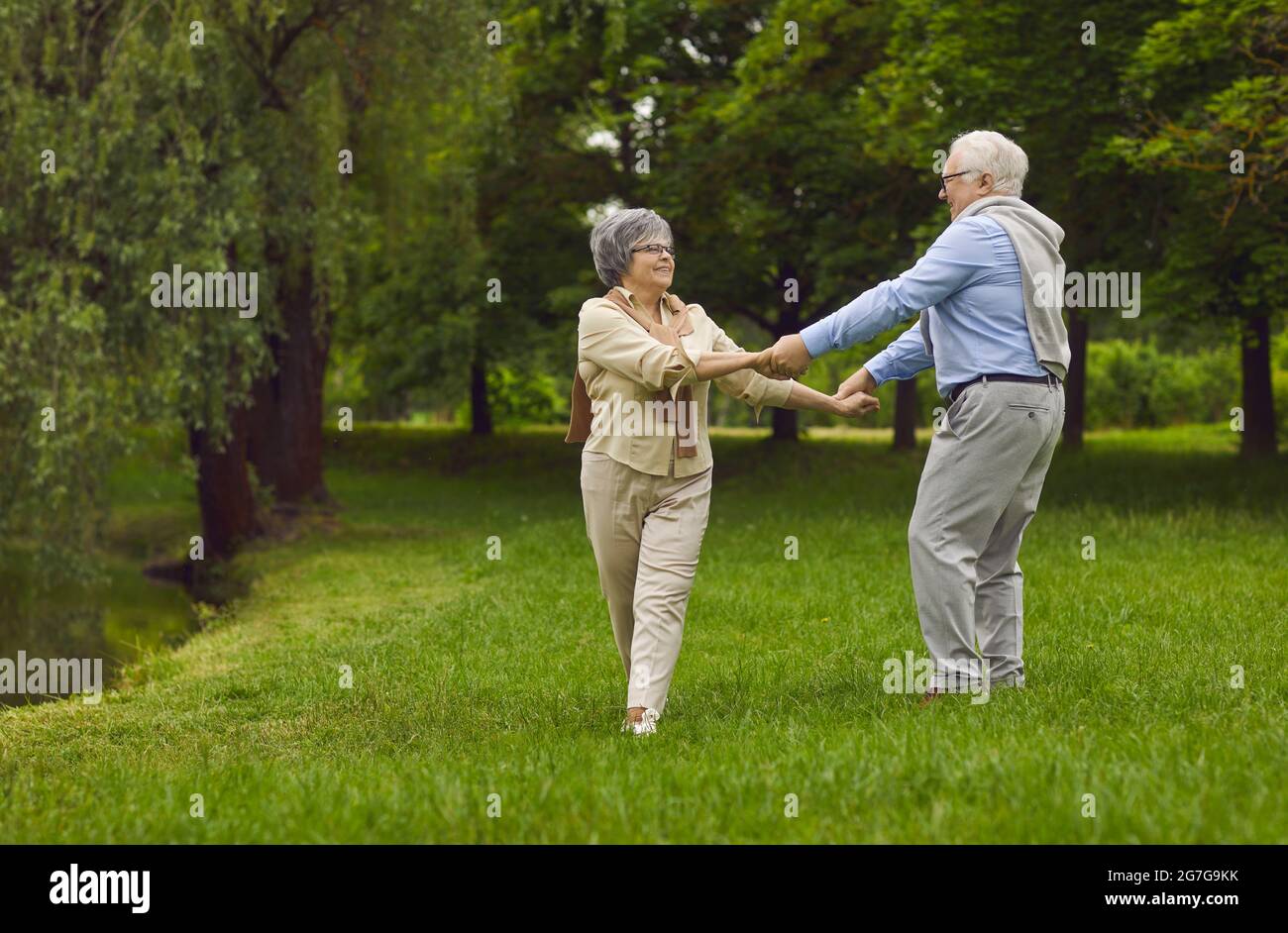 Felici anziani pensionati, uomo e donna, marito e moglie, che ballano insieme Foto Stock