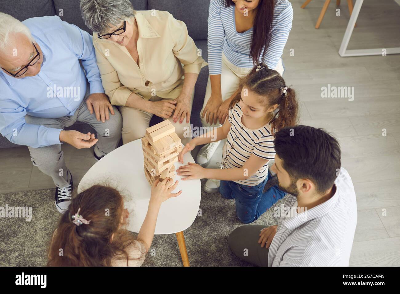 La grande famiglia gioca il gioco da tavolo Jenga. Foto Stock