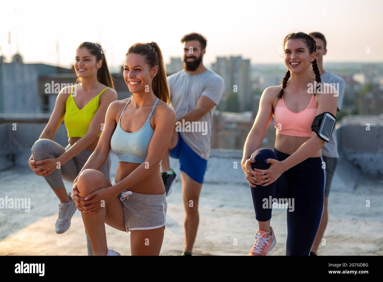 Gruppo di persone felici di fitness che si allenano insieme all'aperto, vivendo uno stile di vita sano e attivo Foto Stock