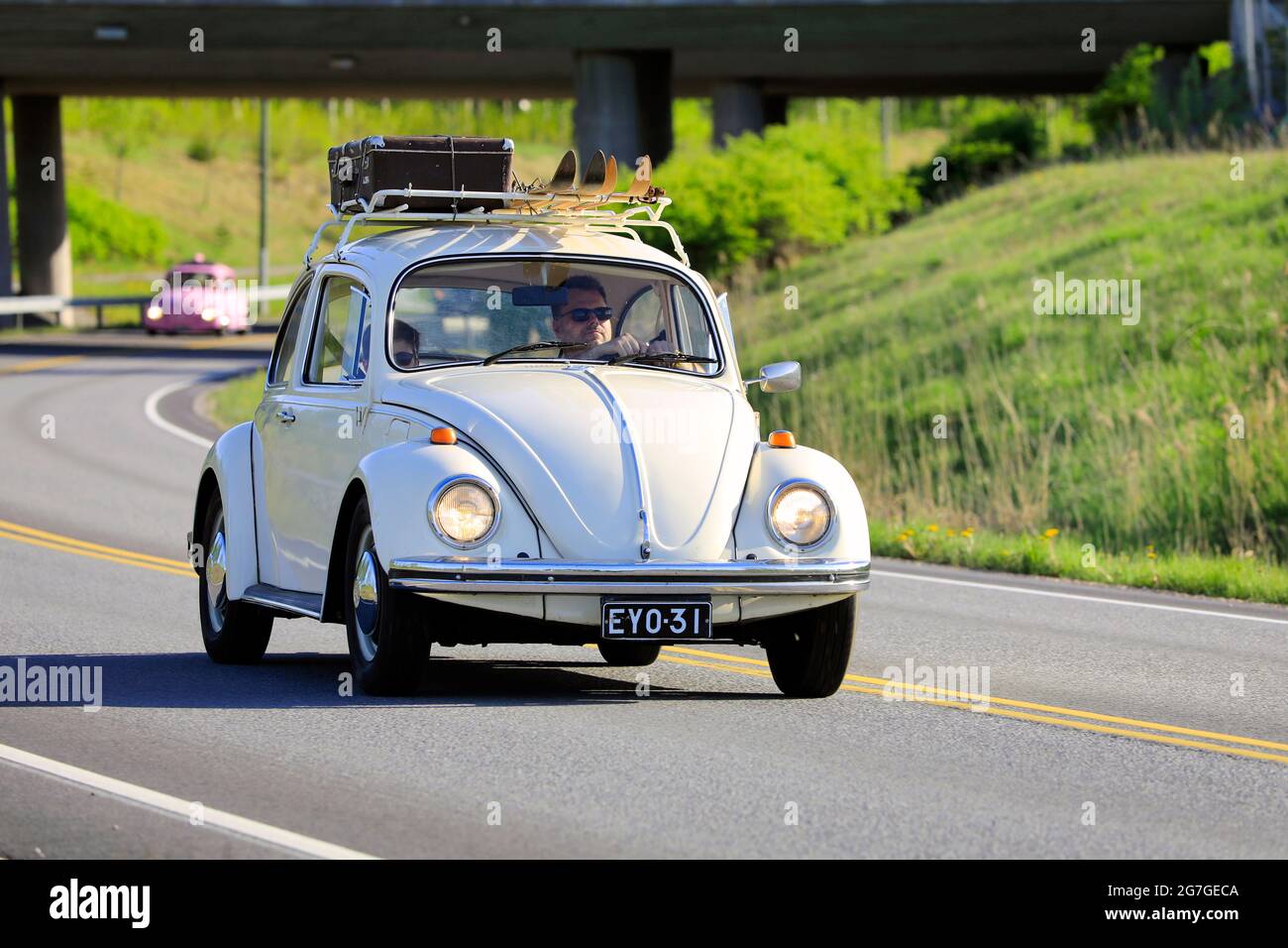 Volkswagen Beetle biancastro, ufficialmente Volkswagen tipo 1, a velocità con bagaglio e due paia di sci sul portapacchi. Salo, Finlandia. 18 maggio 2019. Foto Stock