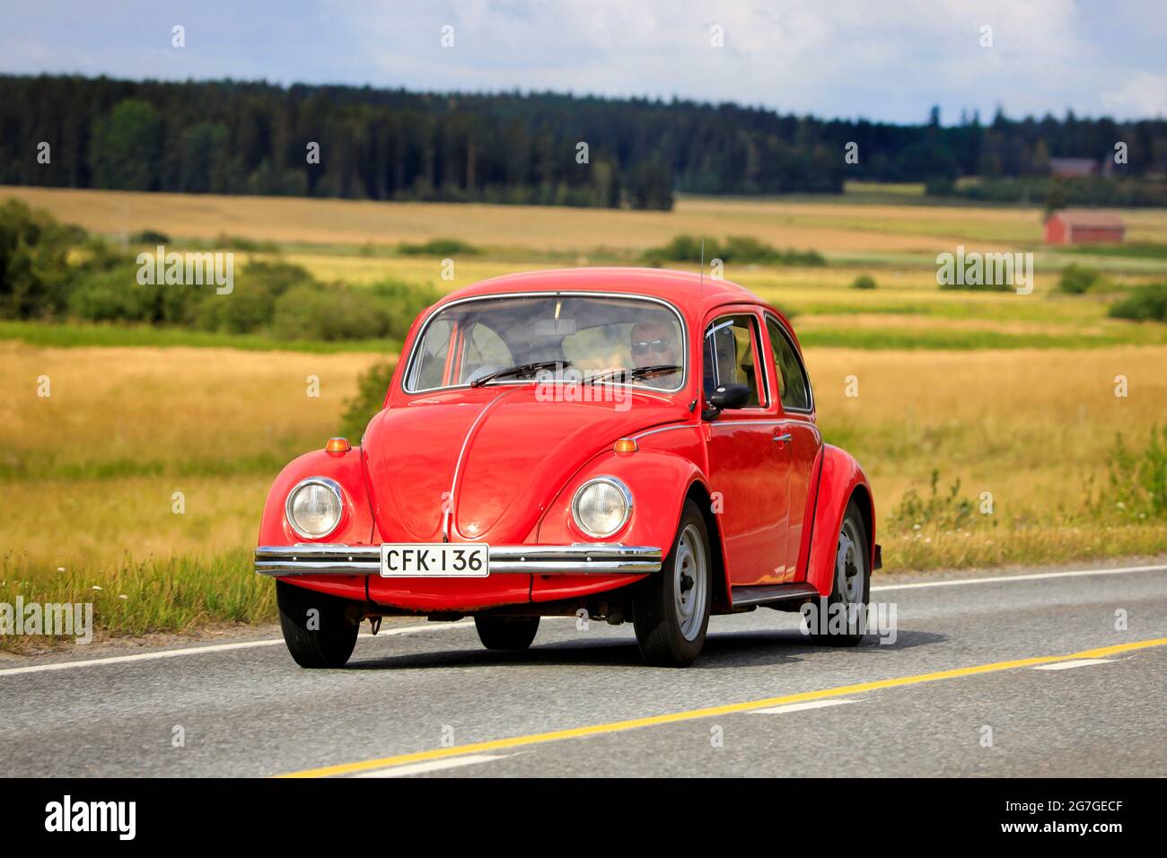 Red Volkswagen Beetle, ufficialmente Volkswagen tipo 1, guidando lungo la strada di campagna sulla crociera di automobile di Maisemaruise 2019. Vaulammi, Finlandia. 3 agosto 2019. Foto Stock